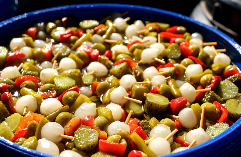 Skewers of gherkins, olives, peppers and pearl onions in a serving bowl
