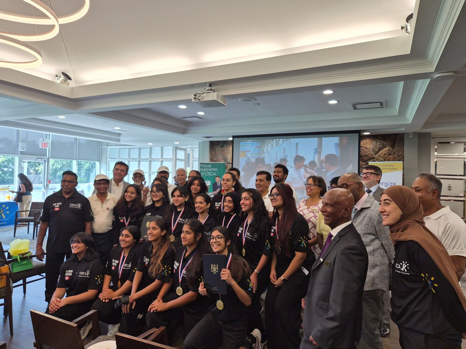 OSCA robotics team members celebrating with medals
