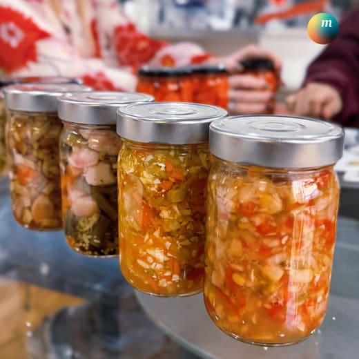Jars of freshly made relish lined up on a display stand