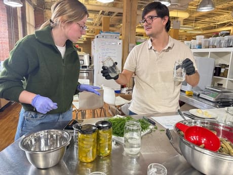 Two team members weighing ingredients in the test kitchen