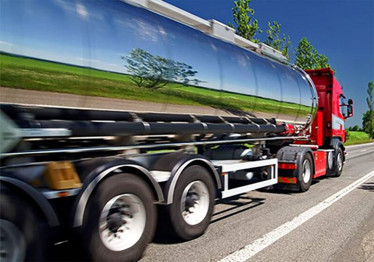 A stainless steel bulk tanker travelling a country road